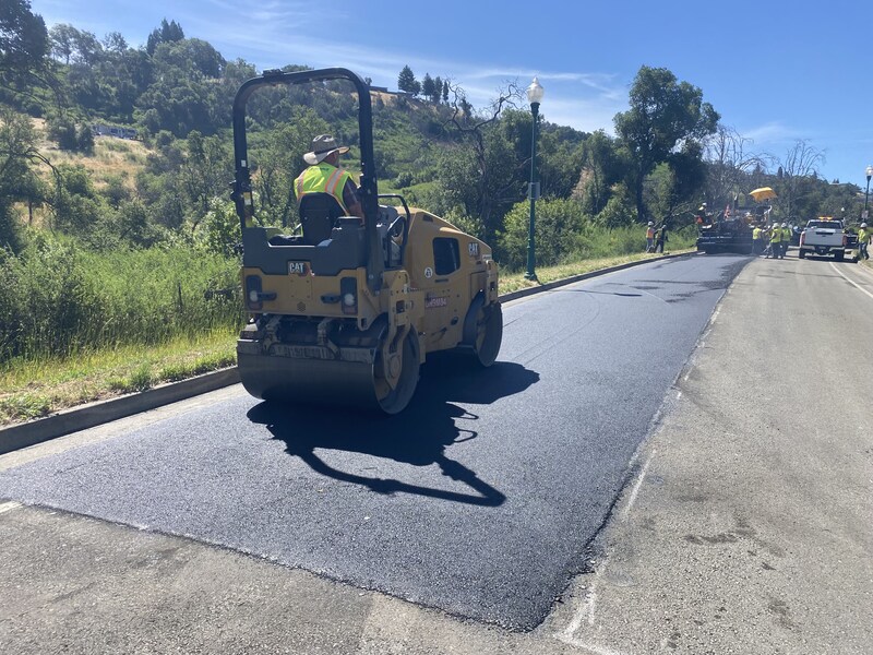 Using a vibratory roller to compact the newly poured asphalt