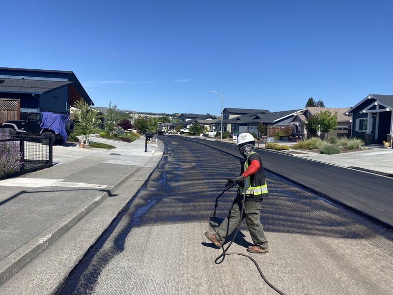 Applying a coat of tack oil to help the new asphalt bond to the existing surfaces
